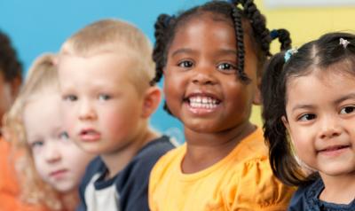 Five diverse children smiling at camera